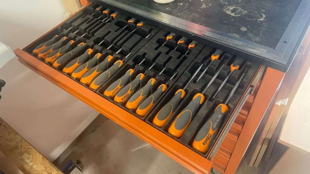 Drawer with neatly stored screwdrivers in a woodworking shop drawer system