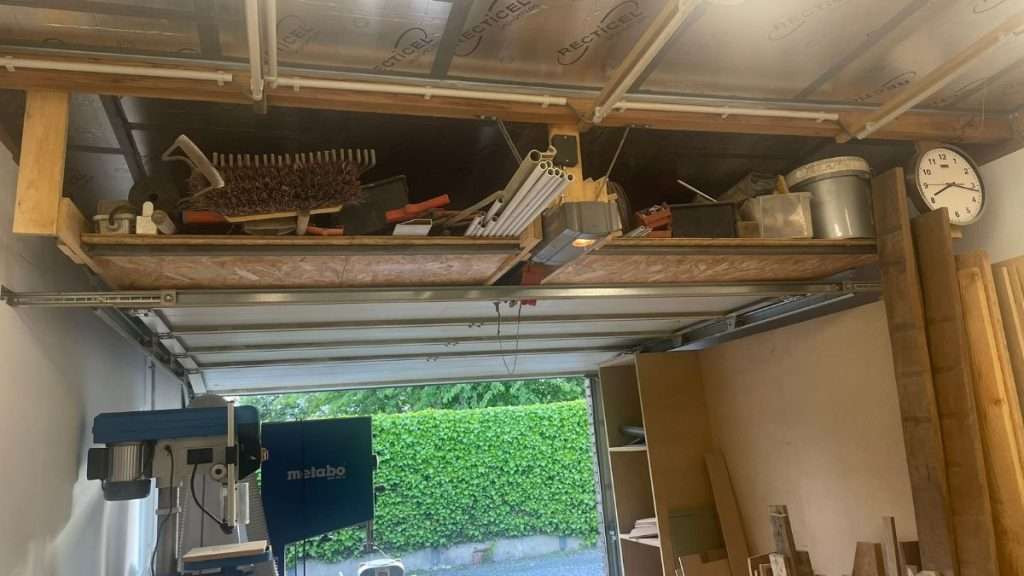 Overhead storage area above garage door in a woodworking workshop