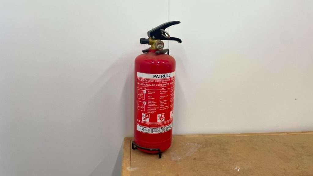 Fire extinguisher installed in a clean and safe woodworking shop.