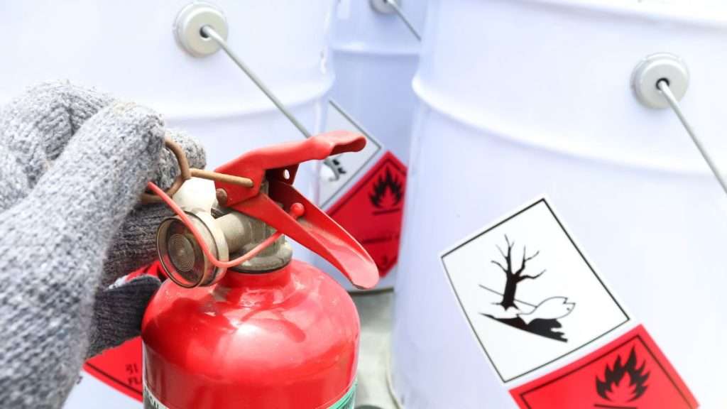 Chemical storage and fire safety gear in a well-organized safe woodworking workshop.
