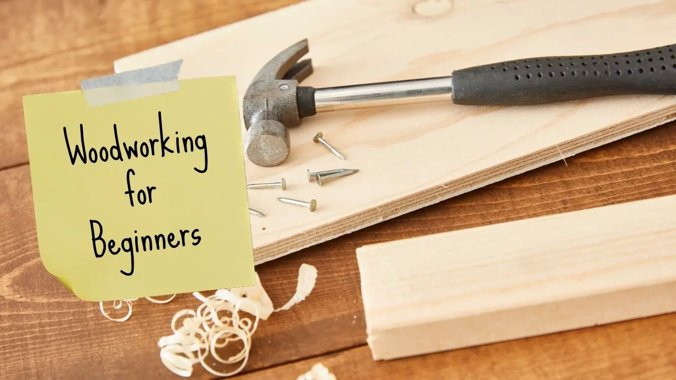 Woodworking for beginners – simple woodworking setup with a hammer, nails, and wooden boards on a workbench.