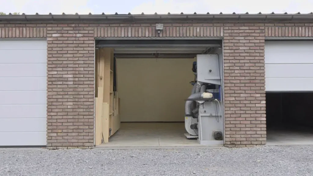 Open garage with tools and lumber as an early setup for a Woodworking Shop Space.