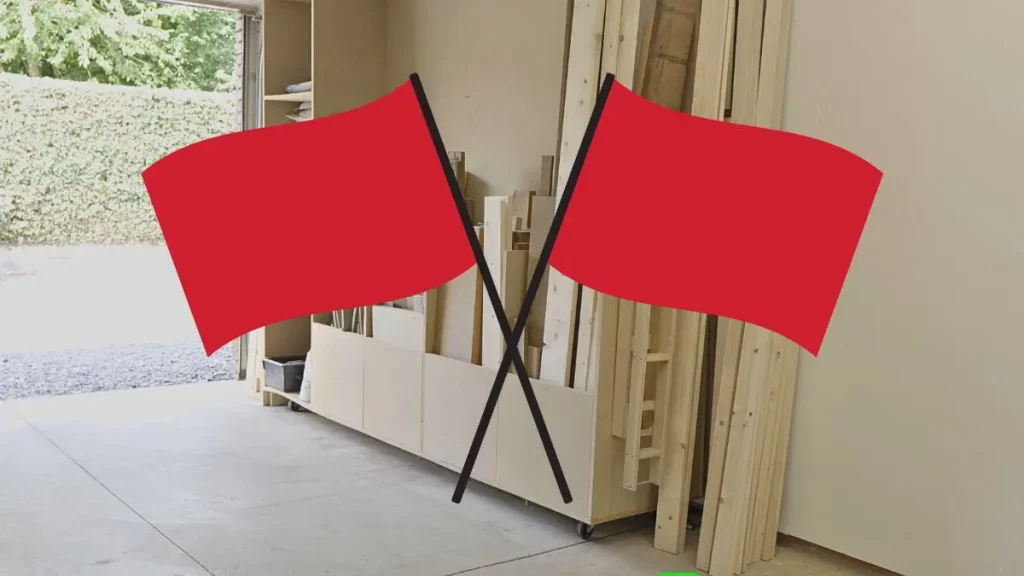 Garage corner with lumber storage and red flags highlighting issues for a Woodworking Shop Space.