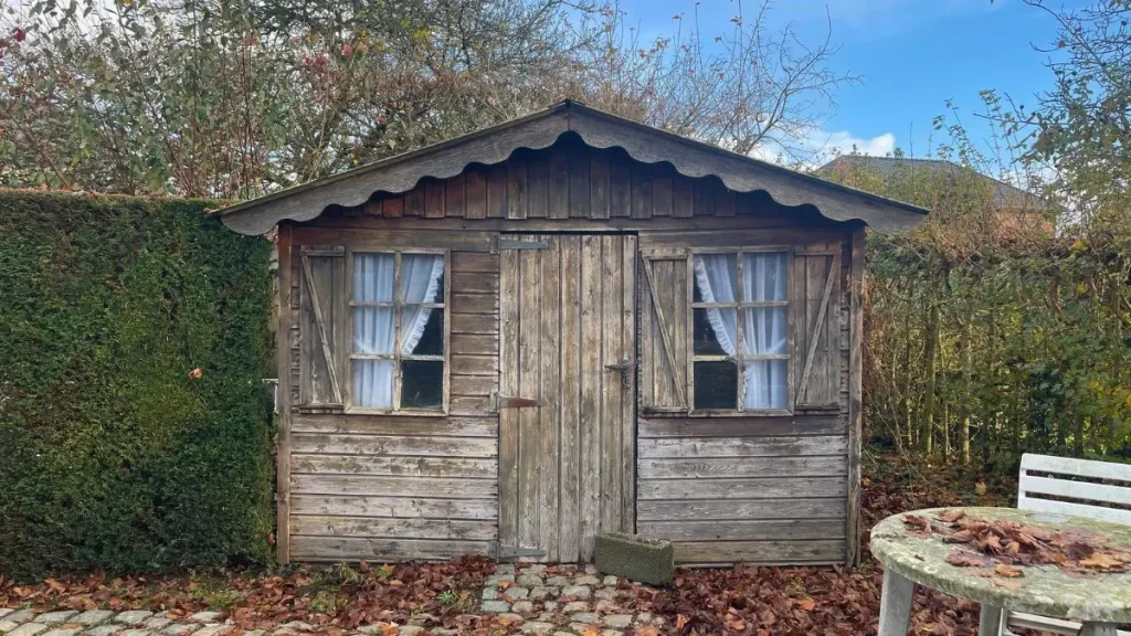 Small wooden shed used as an early workspace for simple woodworking projects.