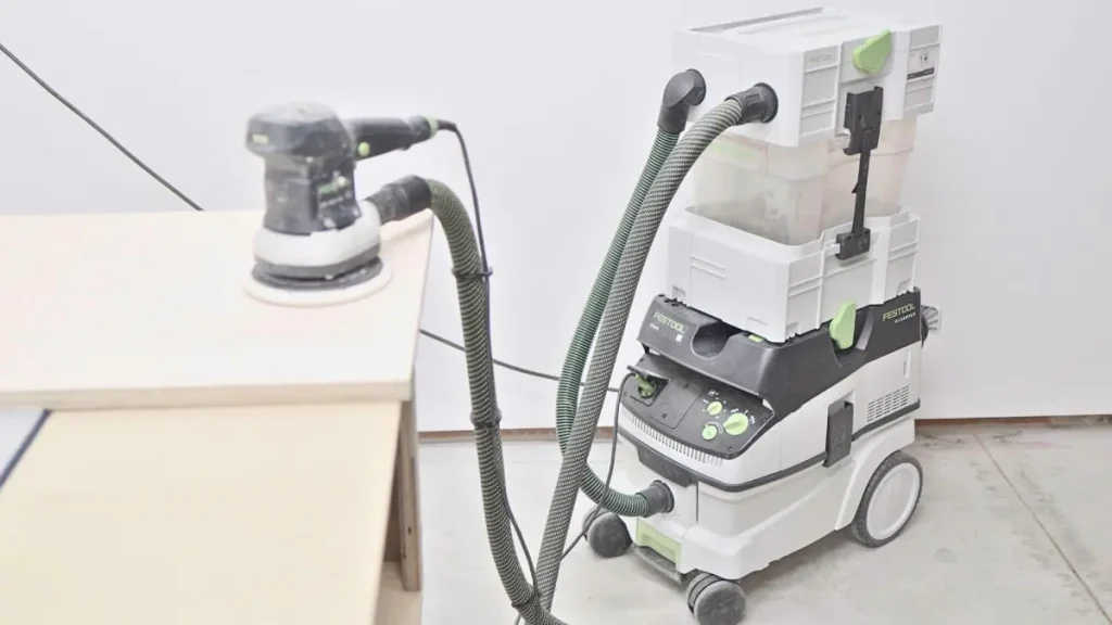 Compact dust extractor and sander set up for clean woodworking in an apartment.