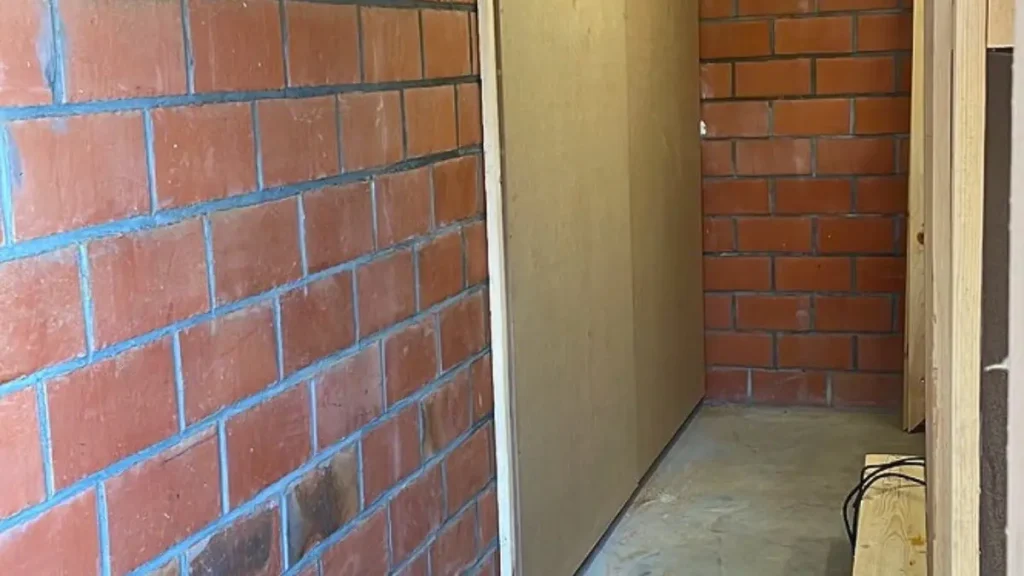 Workshop wall with hollow brick and a thin frame covered in 12 mm MDF as part of preparing a woodworking shop.
