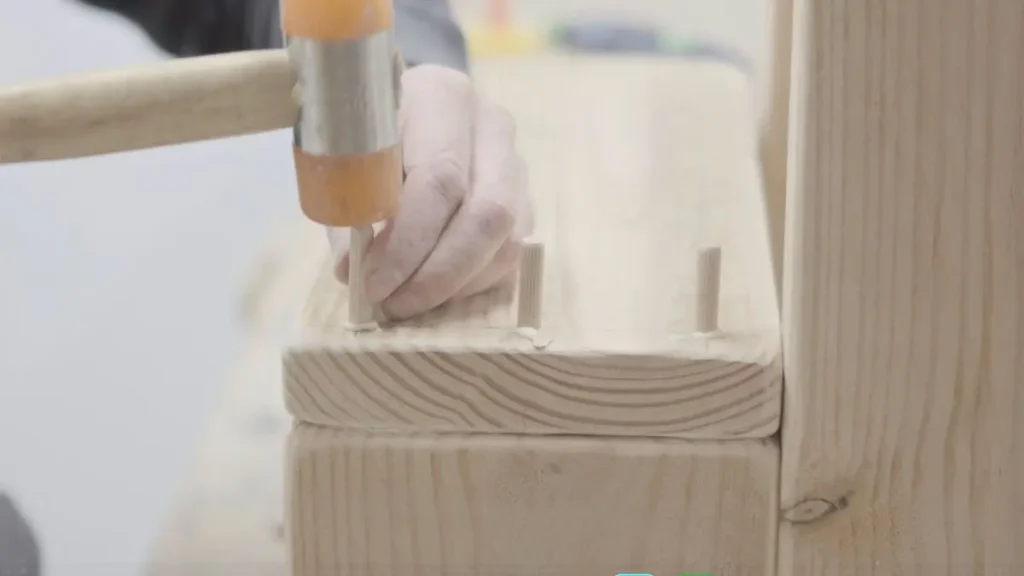 Dowels being tapped into place as part of classic woodworking techniques for strong joinery