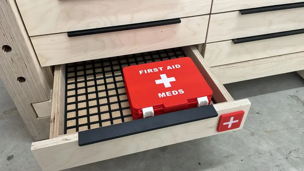 A first aid kit stored in a workshop drawer as part of basic woodworking safety.