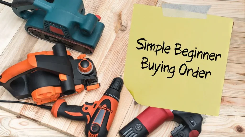 Tools laid out on a wooden surface next to a note that explains a simple buying order for Woodworking Tools for beginners.
