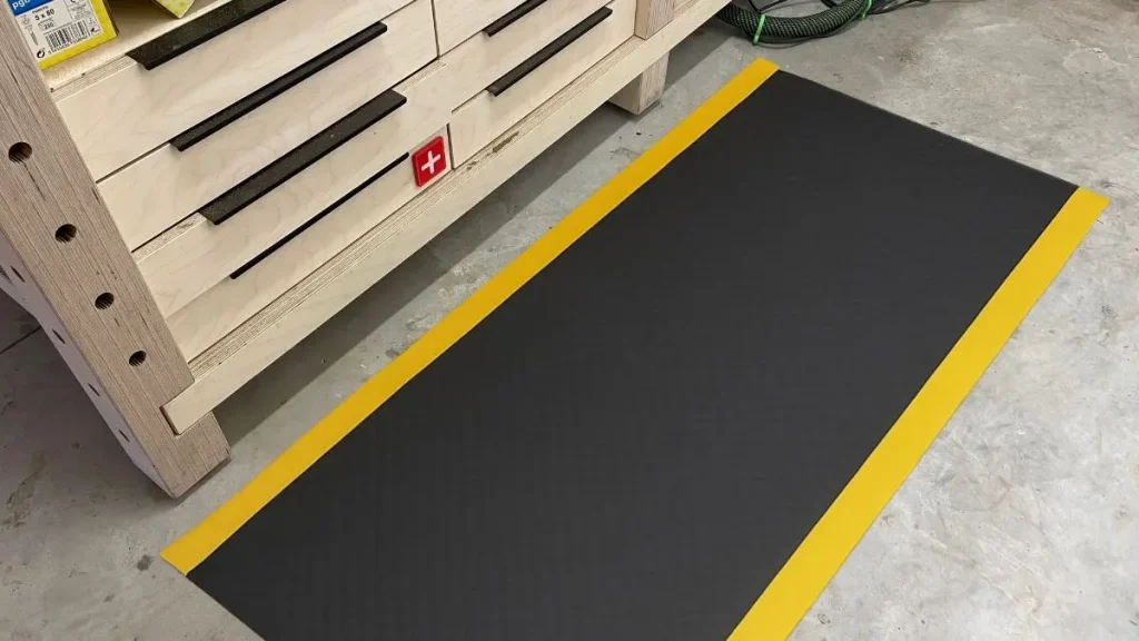 Anti fatigue mat placed in front of a woodworking bench where long sanding and assembly sessions usually happen.