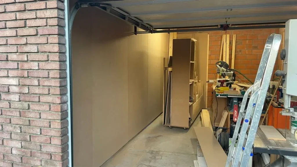 MDF panels installed along a workshop wall before applying the best paint for workshop walls.